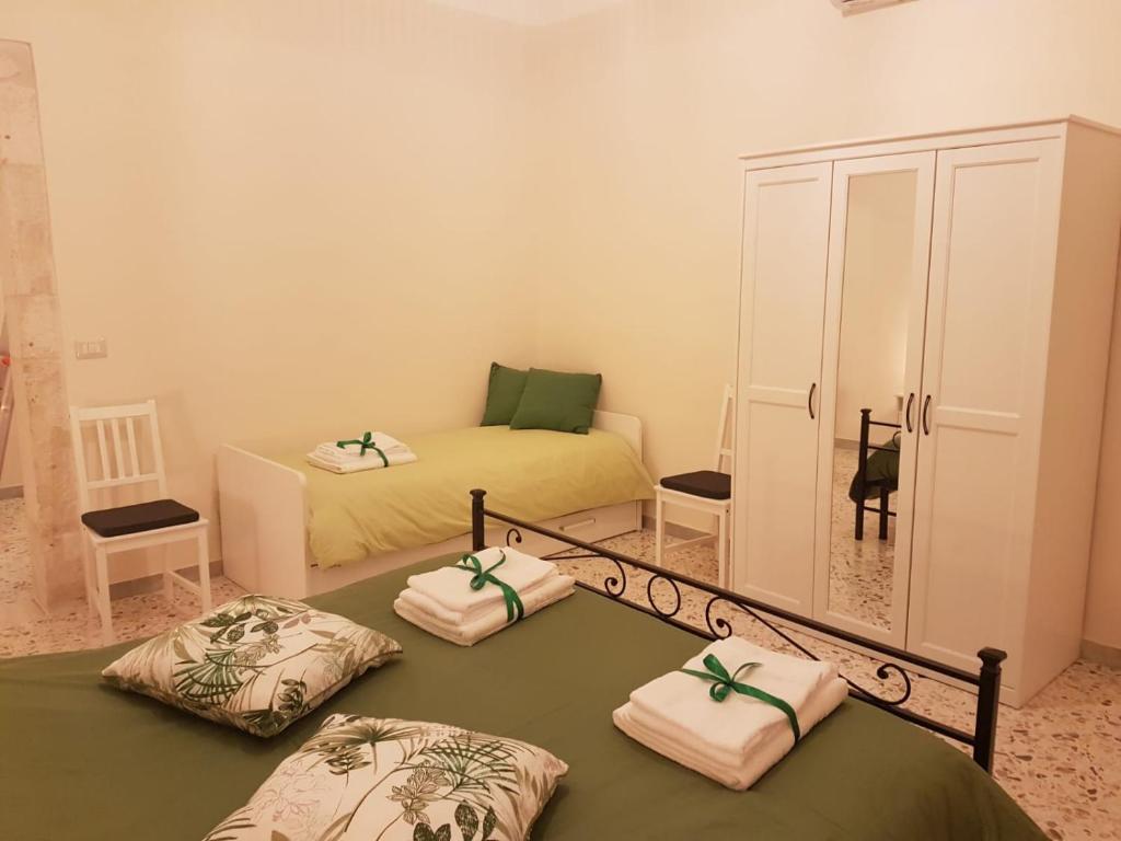 普蒂尼亚诺CASA CAIROLI PUTIGNANO的客房设有两张床和带毛巾的橱柜。