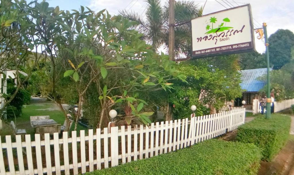 柴老海滩Thongsuwan Resort的一条白色的栅栏,上面有餐厅标志