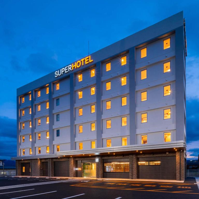 饭田市Super Hotel Nagano Iida Inter的建筑一侧有标志的酒店