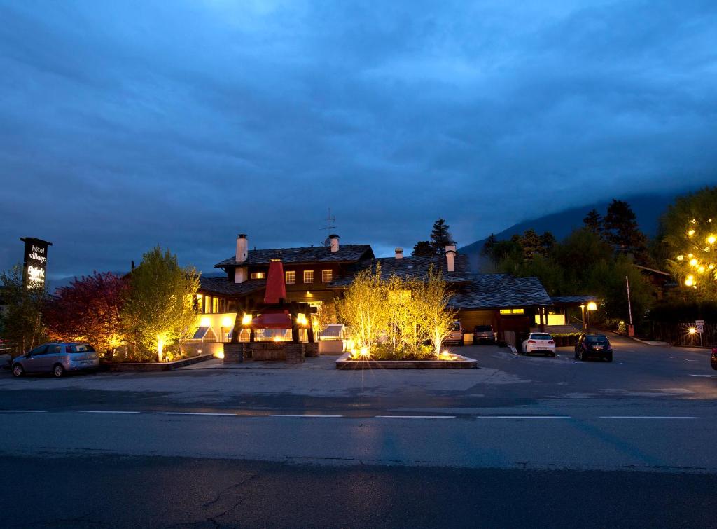 奥斯塔乡村酒店的夜间停车场灯火通明的建筑物