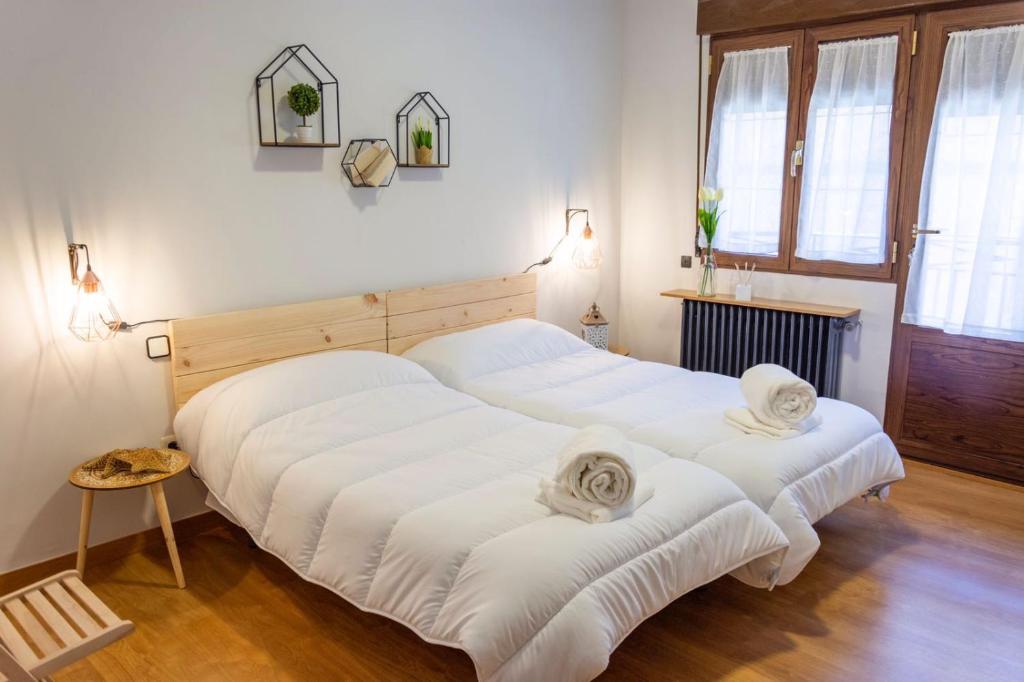 马德里德霍斯Toledo Mágico的配有白色床单的客房内的两张床