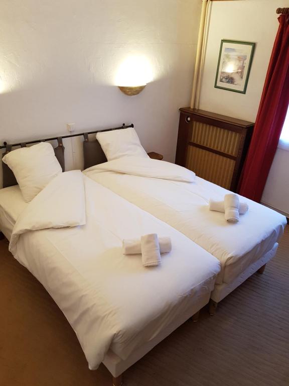 FixinChez Jeannette的两张位于酒店客房的床,配有毛巾