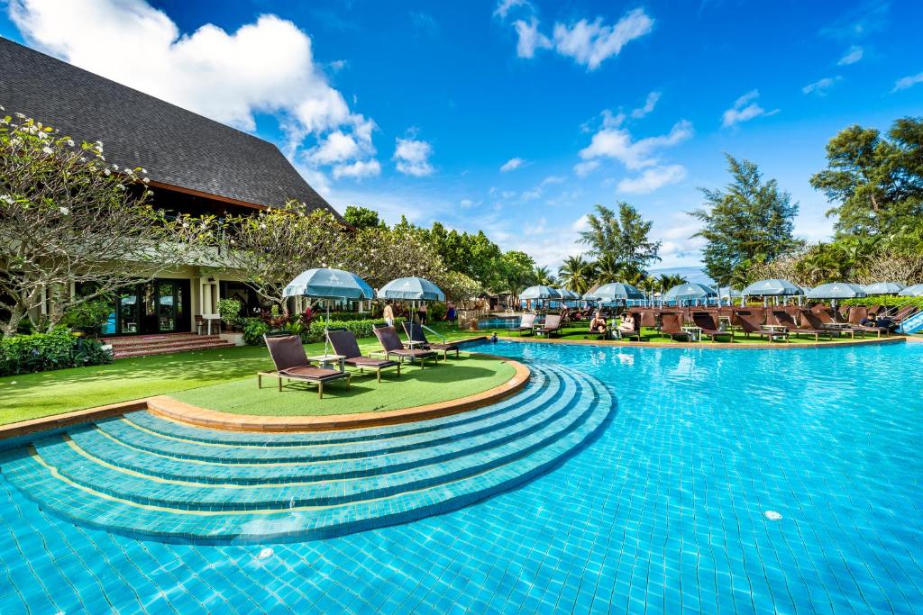 高兰Chada Lanta Beach Resort - SHA Extra Plus的度假村的游泳池,配有椅子和遮阳伞