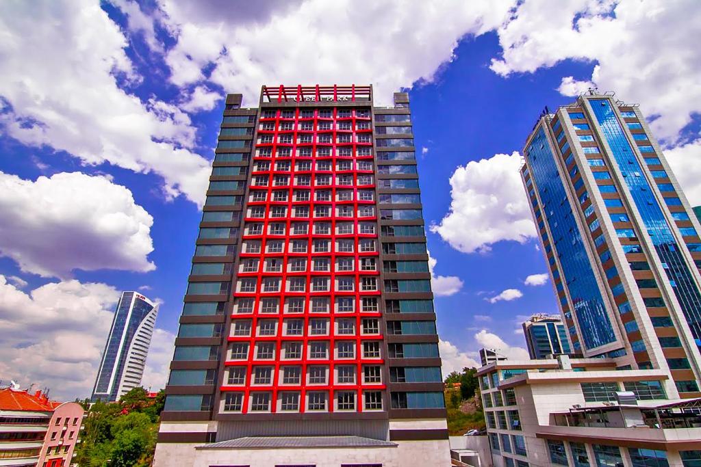 安卡拉The Green Park Ankara的一座高大的建筑,在城市里装有红色窗户