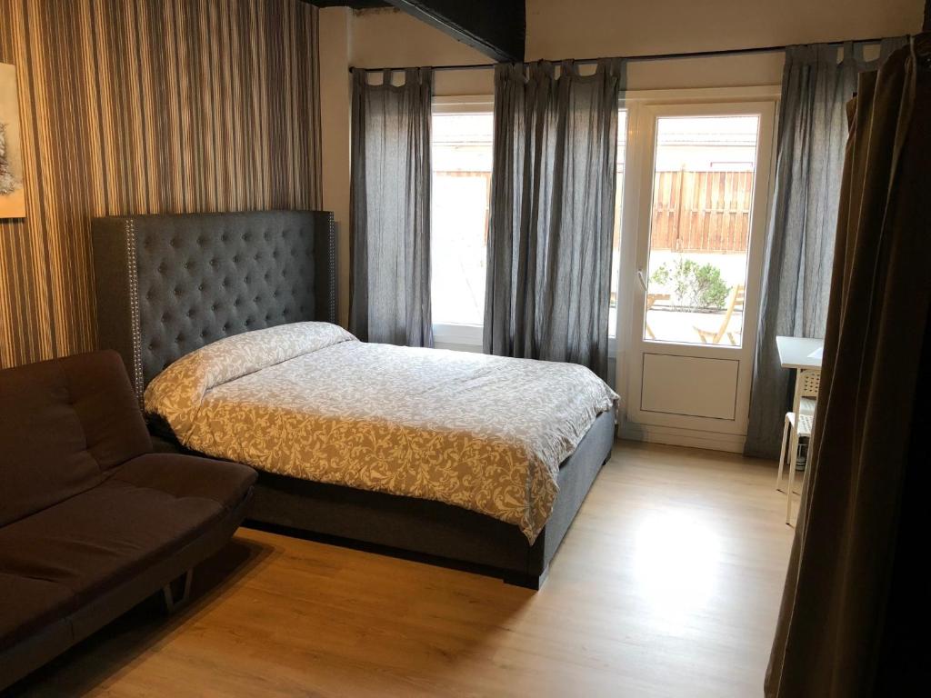 毕尔巴鄂Estudios Bilbao Deusto的一间卧室配有一张床、一张沙发和一个窗口