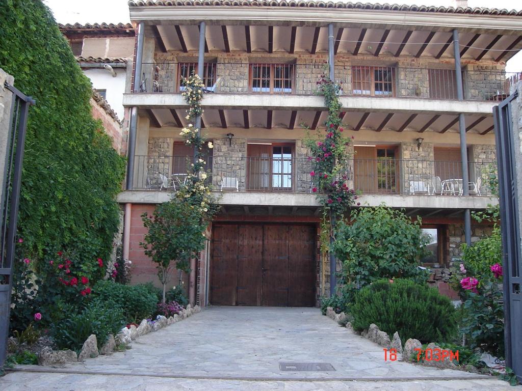 赫亚德亚尔瓦拉辛Apartamentos el Portal的一座带木门和鲜花的大房子