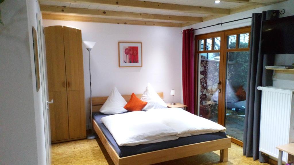 EckersdorfApartment mit Gartenblick的一间卧室配有带白色床单和橙色枕头的床。