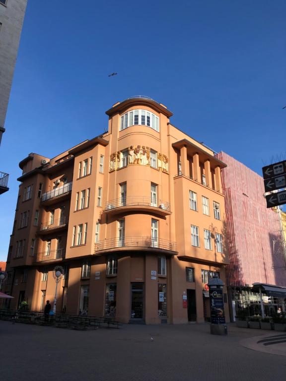 萨格勒布Main Square Oval Apartment的带阳台的棕褐色建筑