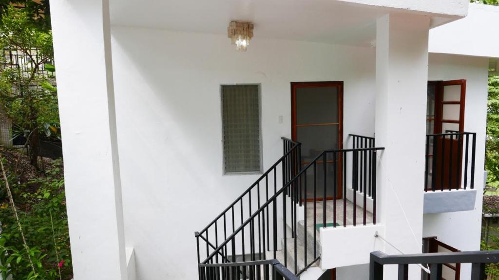 TugbonganJSB Residences Cebu A-flat的白色的房子,设有楼梯和窗户