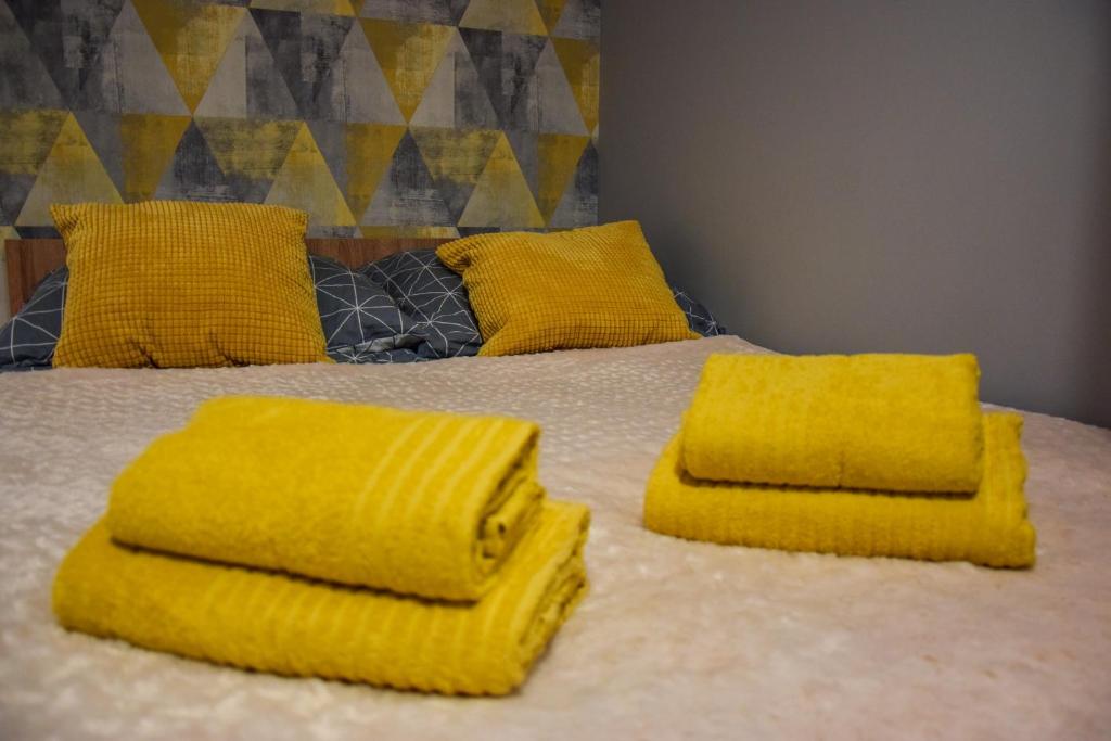 克拉科夫Mogilska Tower + garaż的床上有黄色毛巾的床