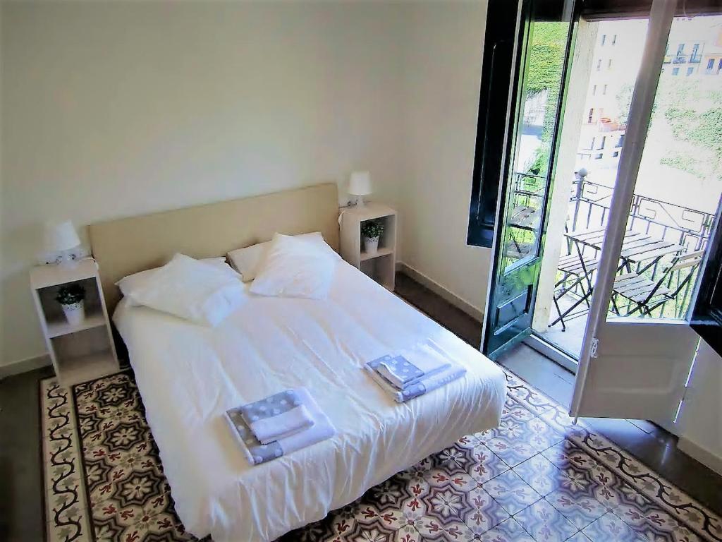 赫罗纳Apartamento Les Pedreres的卧室配有白色的床和2盘盘