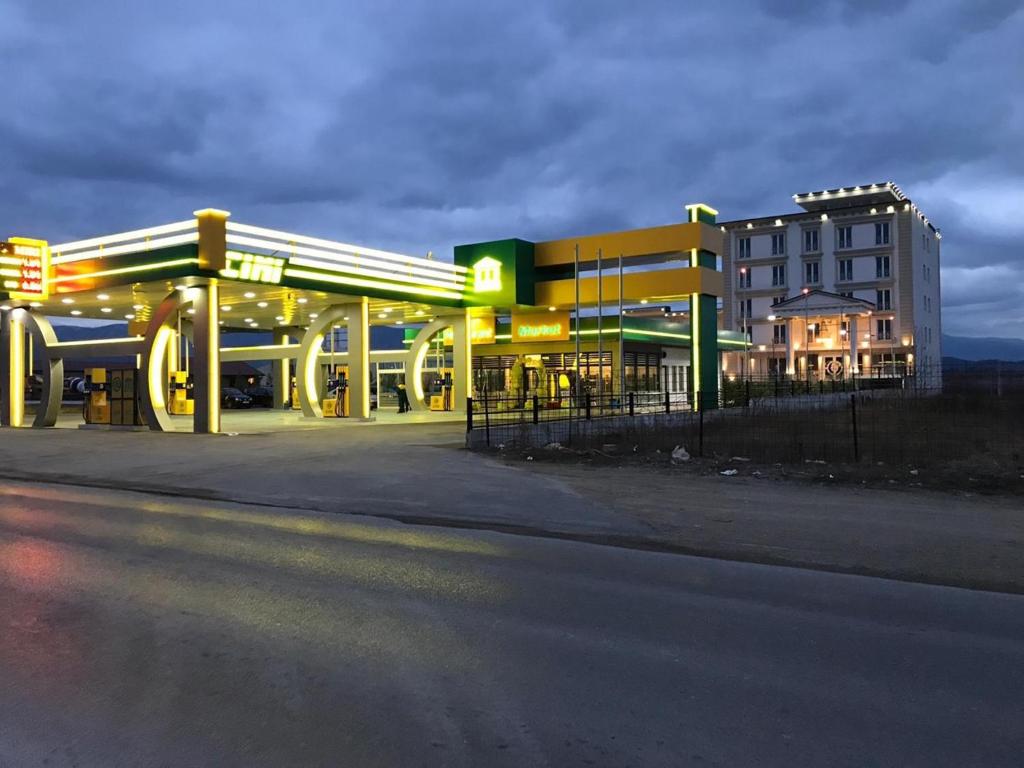 普里兹伦特兰达酒店的夜间建筑物前的加油站