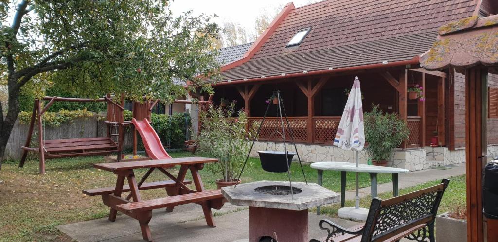 奥巴曹洛克Alexandra Vendégház的后院,带长椅,火坑和房子