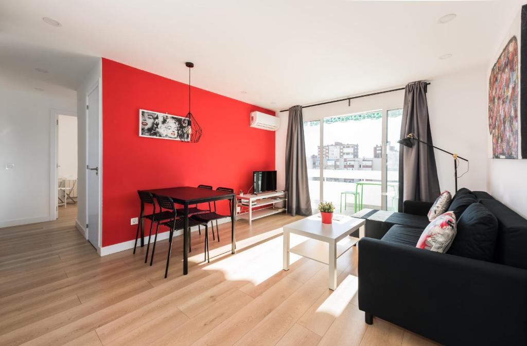 马德里Ever House IFEMA Mar de Cristal的客厅配有黑色沙发和红色墙壁