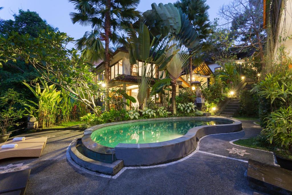 乌布乌布圣猴森林拉哈宇酒店的一座树木繁茂的房屋前的游泳池