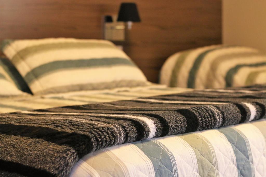 圣罗克Stefano Hotel的两张带条纹枕头的床彼此相邻