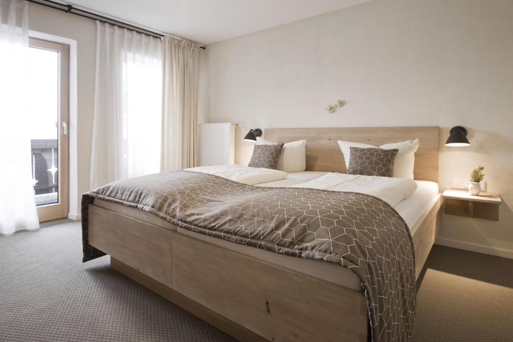 加尔米施-帕滕基兴巴伐利亚生态酒店的一间卧室设有一张大床和一个大窗户