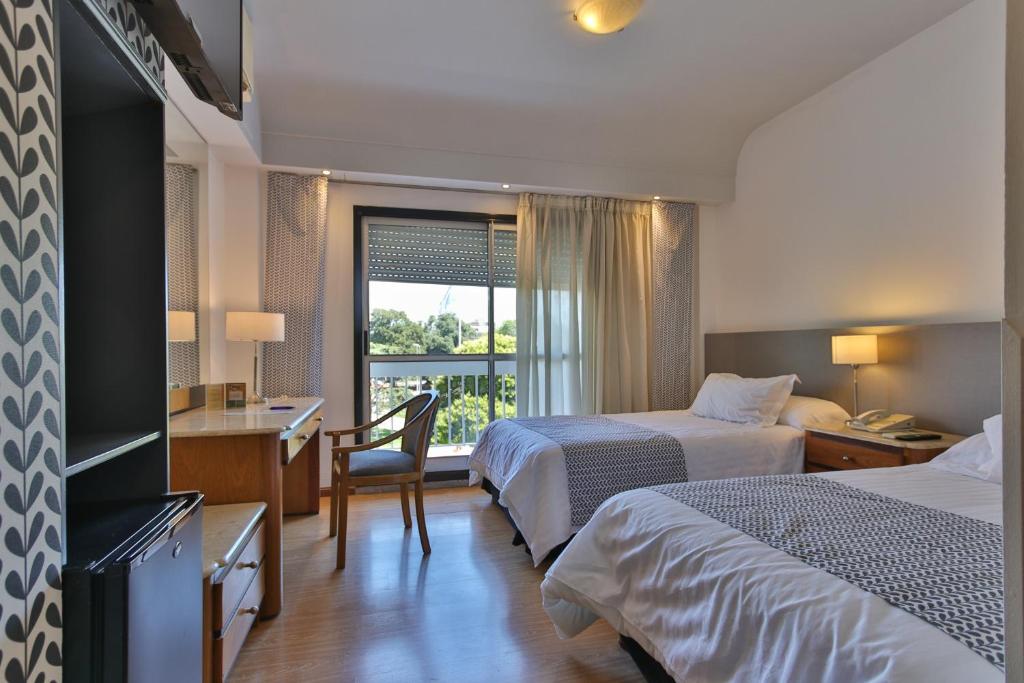 巴拉那巴拉那大酒店的酒店客房设有两张床、一张书桌和一个窗户。