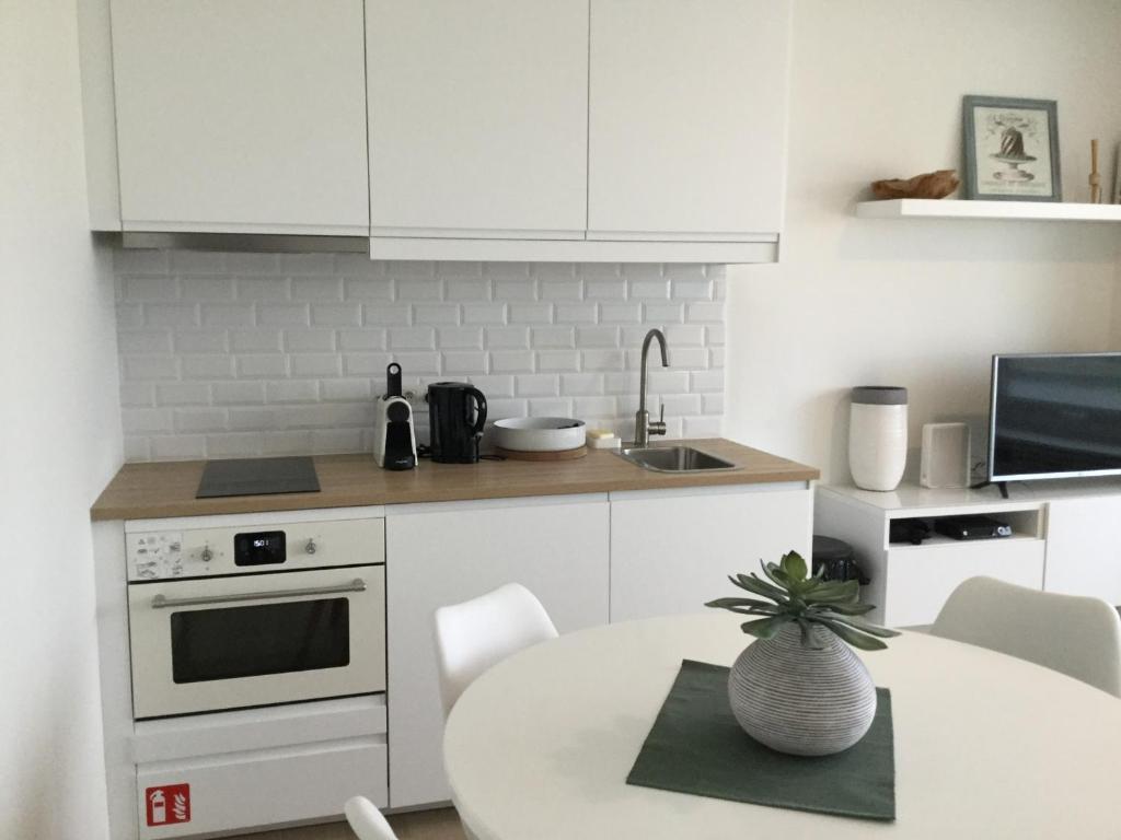 奥斯坦德hill4的厨房配有白色橱柜和植物桌子