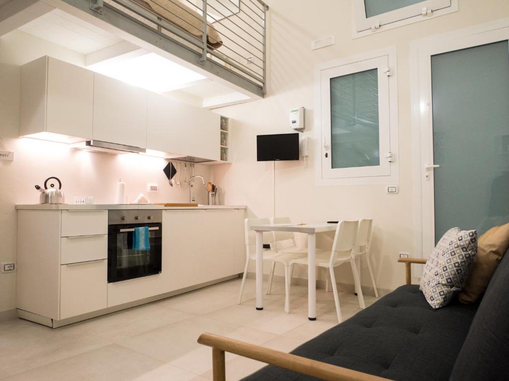 巴里San Nicola Studio Apartments - Barivecchia的厨房以及带桌子和沙发的客厅。