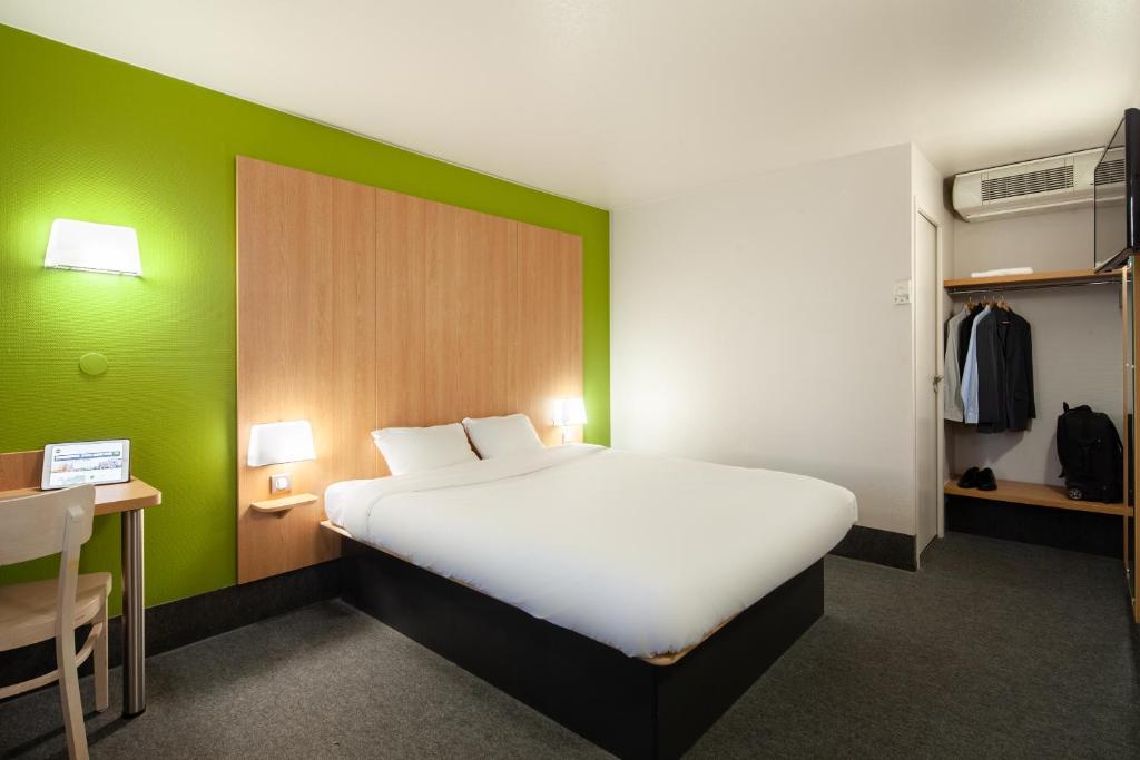 埃尔布莱B&B HOTEL Herblay的卧室配有白色的床和绿色的墙壁