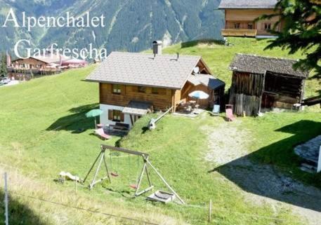 圣加伦基希Alpenchalet Garfrescha的绿色山顶上的一个小房子