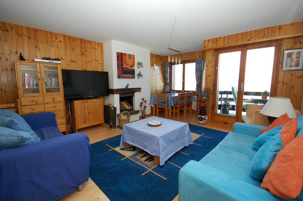 南达La Foret Apartment With Spectacular Mountain Views的客厅配有蓝色的沙发和桌子