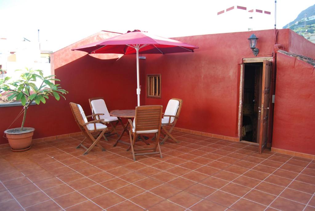 加拉奇科LA CASITA DEL MUELLE的庭院配有桌椅和遮阳伞。