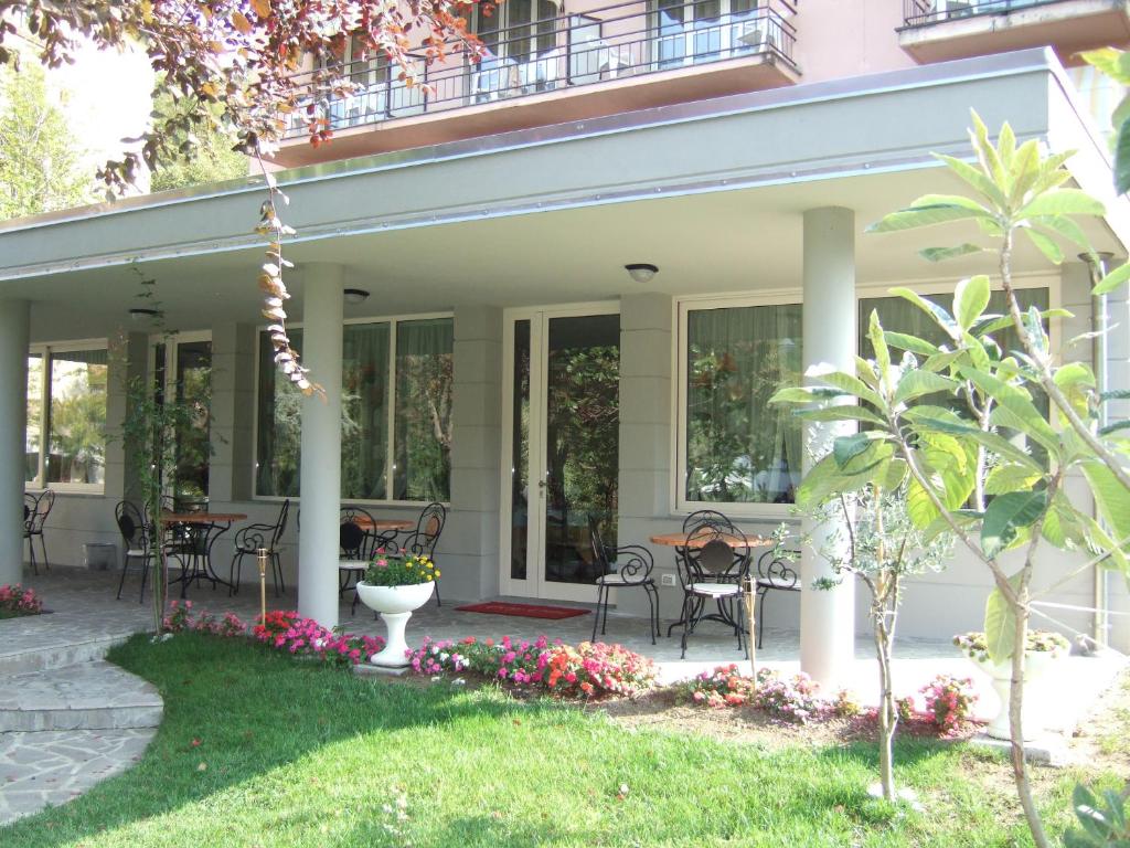 塔皮安诺Albergo Elvira的房屋设有带桌椅的庭院