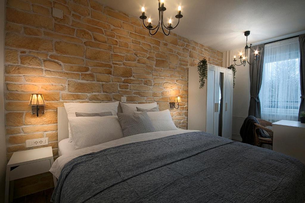 普利特维采湖L&L Leisure Apartments Plitvice的一间带砖墙和大床的卧室