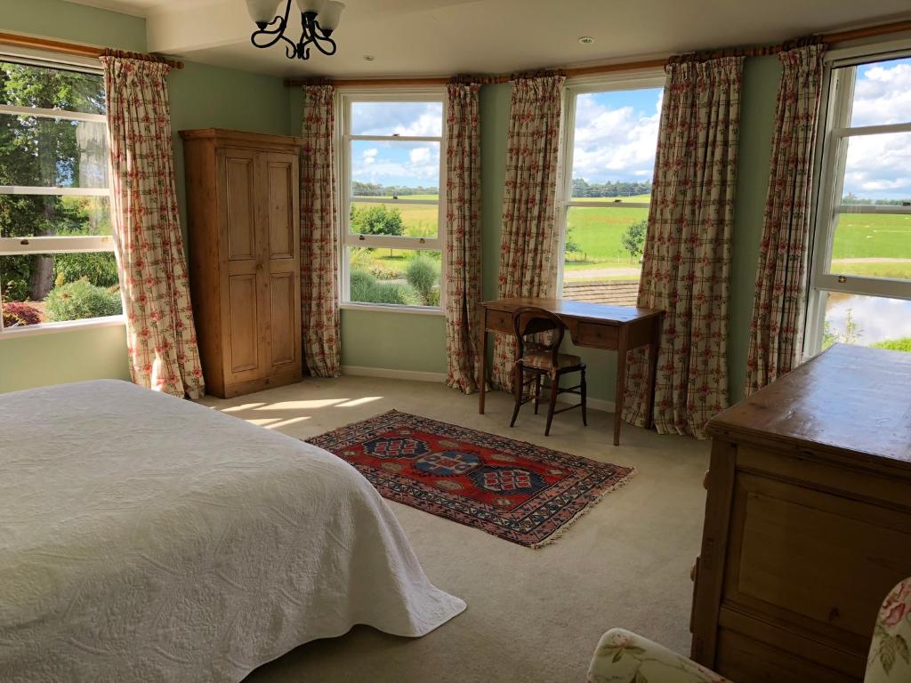 马丁伯勒Te Kopura Lodge的卧室配有一张床、一张书桌和窗户。