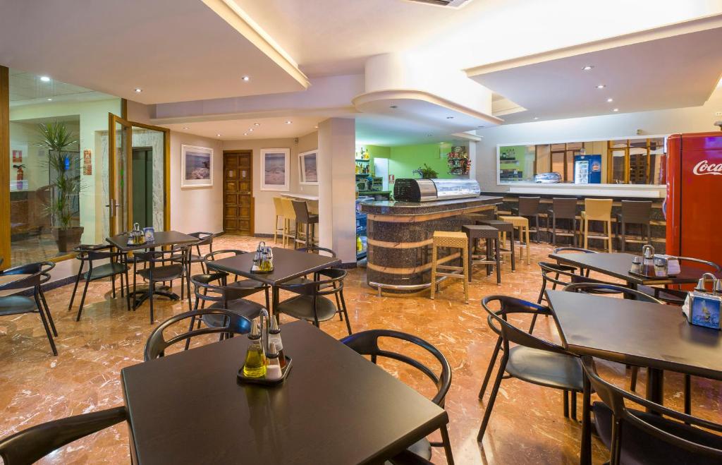 圣安东尼奥阿利坎特旅舍的一间带桌椅的餐厅和一间酒吧