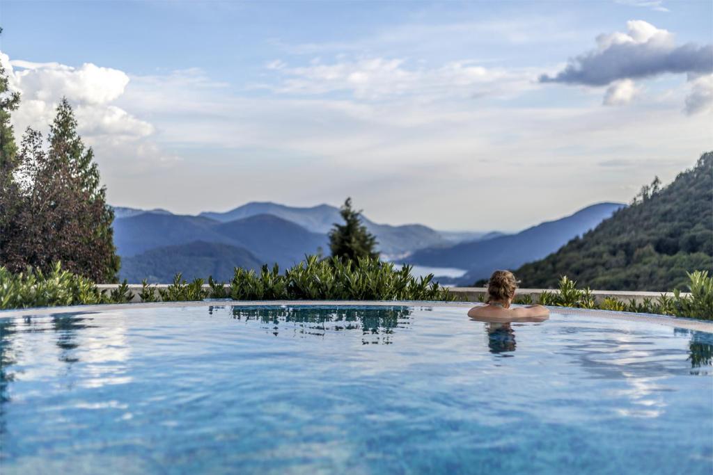 卡迪马里奥Kurhaus Cademario Hotel & DOT Spa - Ticino Hotels Group的山地游泳池里的人