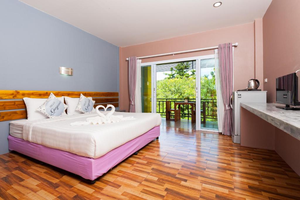 涛岛阁道岛绿茵度假酒店的一间带大床的卧室和一个阳台