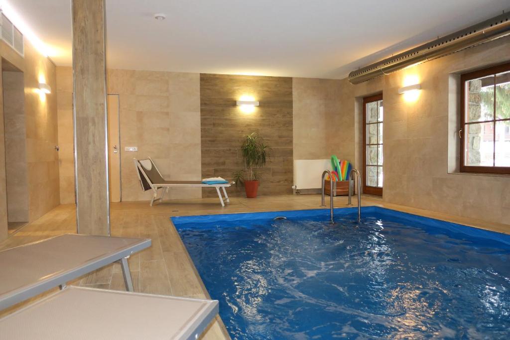 哈拉霍夫和雷本卡小木屋酒店的一个带大型蓝色泳池的房间的游泳池