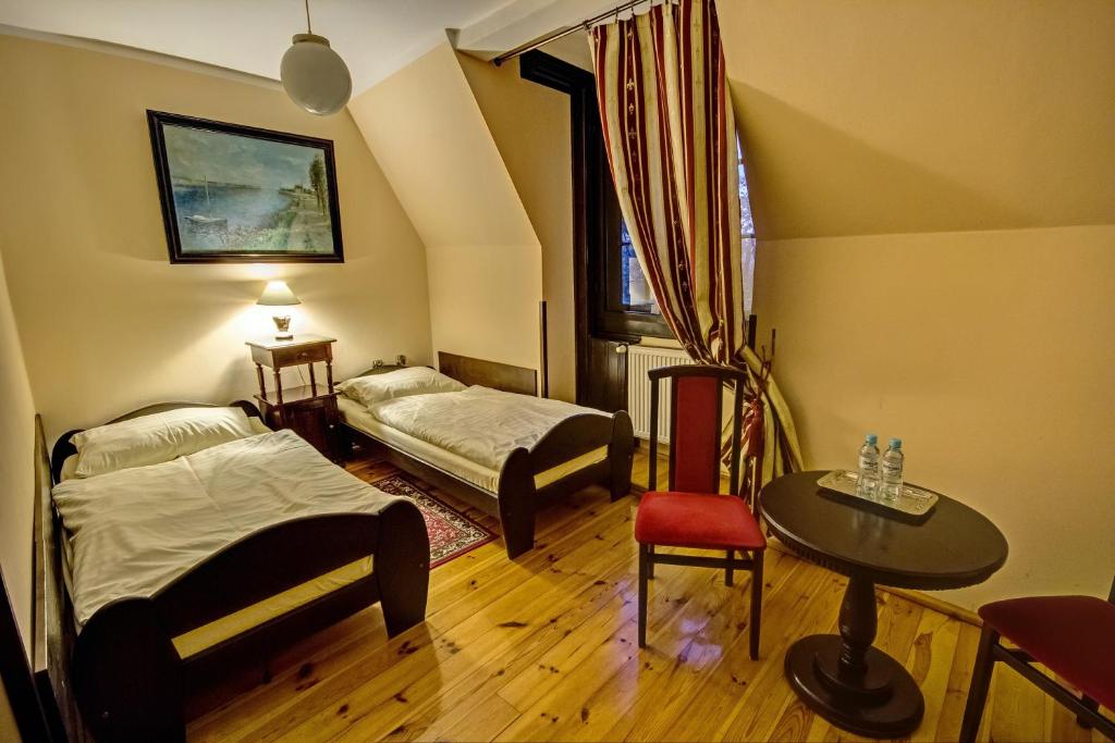 弗罗茨瓦夫省孔蒂克洛碧洛维萨宫殿酒店的一间设有两张床、一张桌子和一把椅子的房间