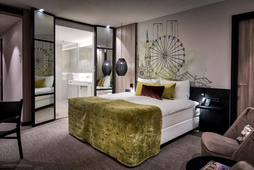 蒂尔堡Van der Valk Hotel Tilburg的一间卧室设有一张大床和一个大镜子
