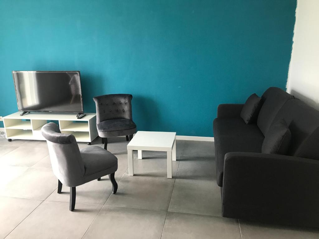 若奈克朗Appartement Futuroscope-J'的客厅配有沙发、椅子和电视