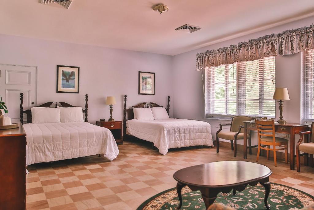 克劳福德维尔The Lodge at Wakulla Springs的一间卧室配有两张床和一张桌子及椅子