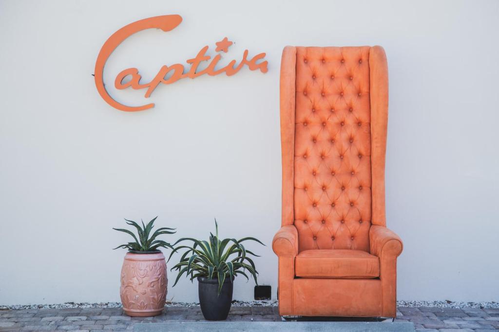 萨拉索塔Captiva Beach Resort (open private beach access)的墙上的橙色椅子和盆栽植物