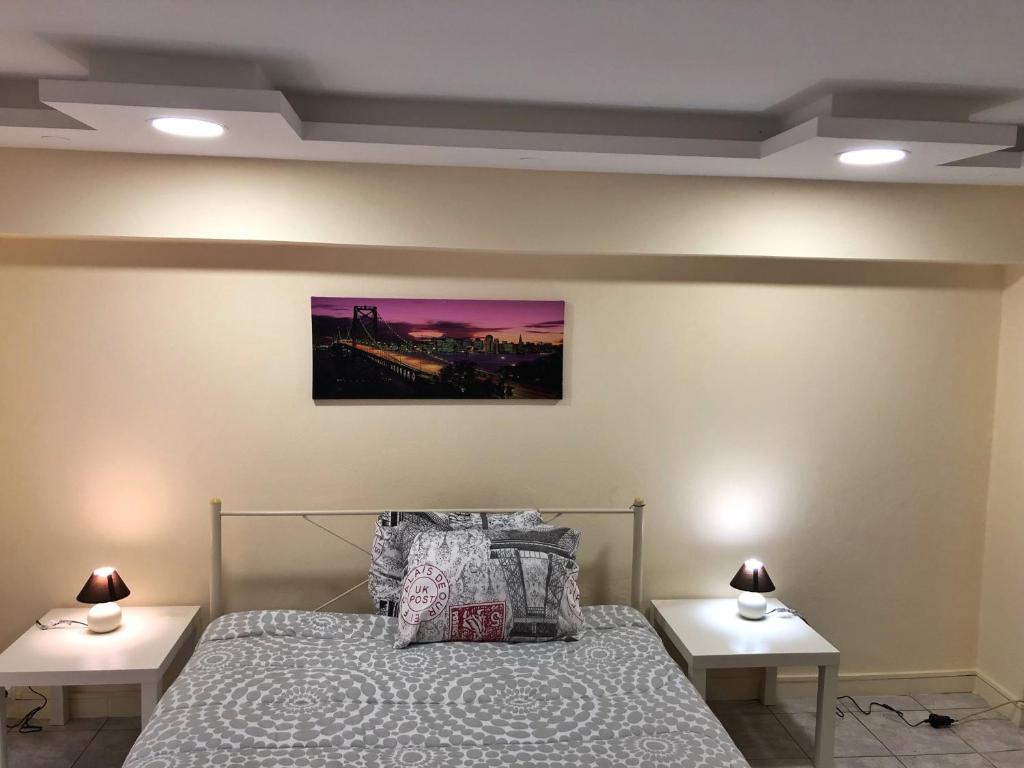 阿特米达sunmer apartment 1minute from sea, 15 min from the airport ARTEMIS CITY CENTER的一间卧室配有床和2张床头柜。