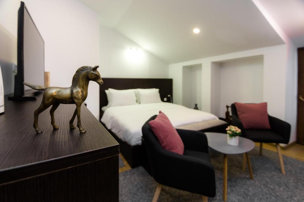 第比利斯VovaDoma的卧室配有一张床,还有一匹马在梳妆台上的雕像