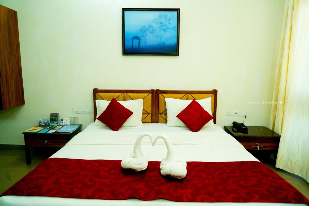 NandiKSTDC Hotel Mayura Pine Top Nandi Hills的床上的2条白色毛巾和红色枕头