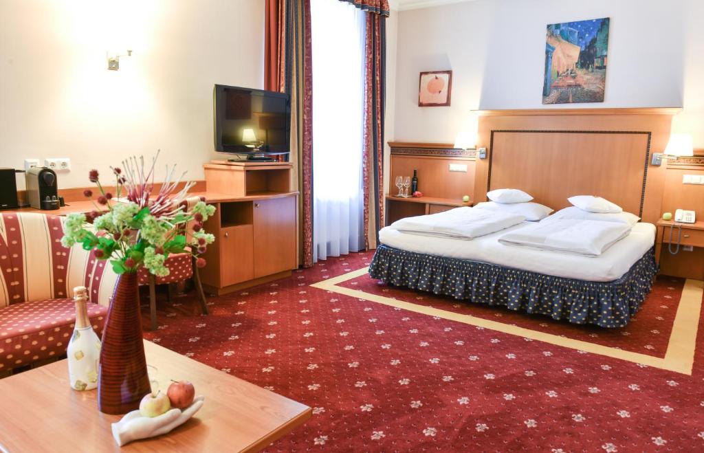 韦尔斯Hotel Alexandra的酒店客房配有一张床铺和一张桌子。