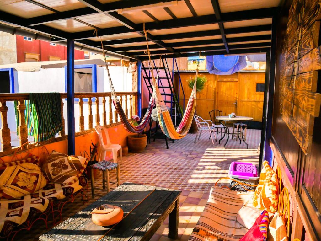 塔姆拉赫特乌兹达尔Surf hostel Morocco的阳台配有吊床和桌椅。