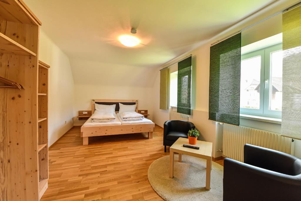 NeuhausGÄSTEHAUS HARTL - Gasthof Hartl, vlg Zum Wirt的一间卧室配有一张床、一张桌子和一把椅子