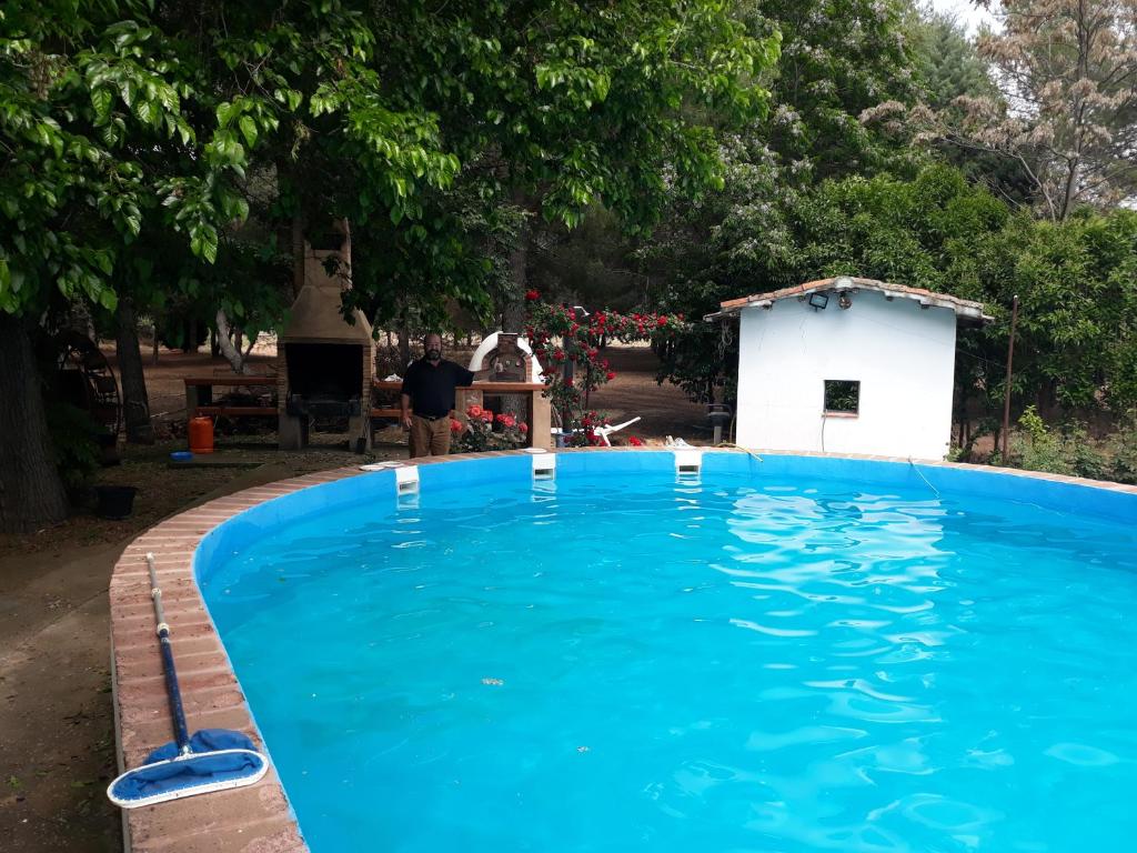 Los QuilesAgroturismo la finka的白色建筑旁边的大型蓝色游泳池