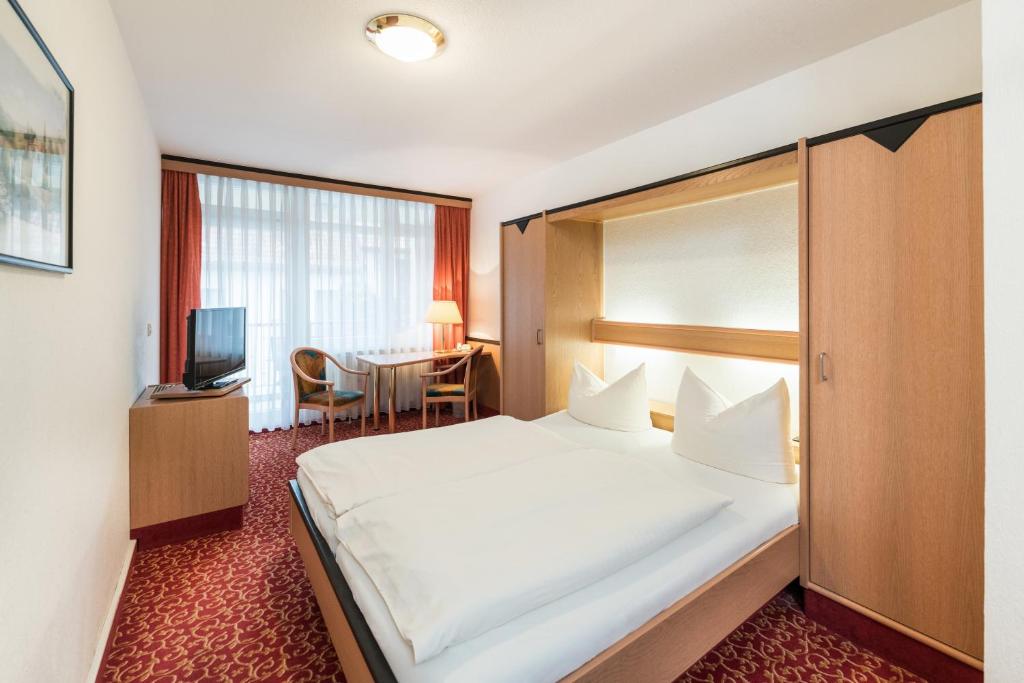 艾森纳赫Hotel am Markt的酒店客房设有一张大床和一张桌子。