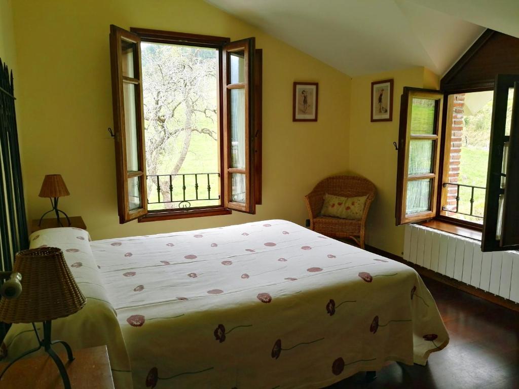 拉马莱斯德拉维克托里亚Finca Artienza的一间卧室设有一张大床和两个窗户。