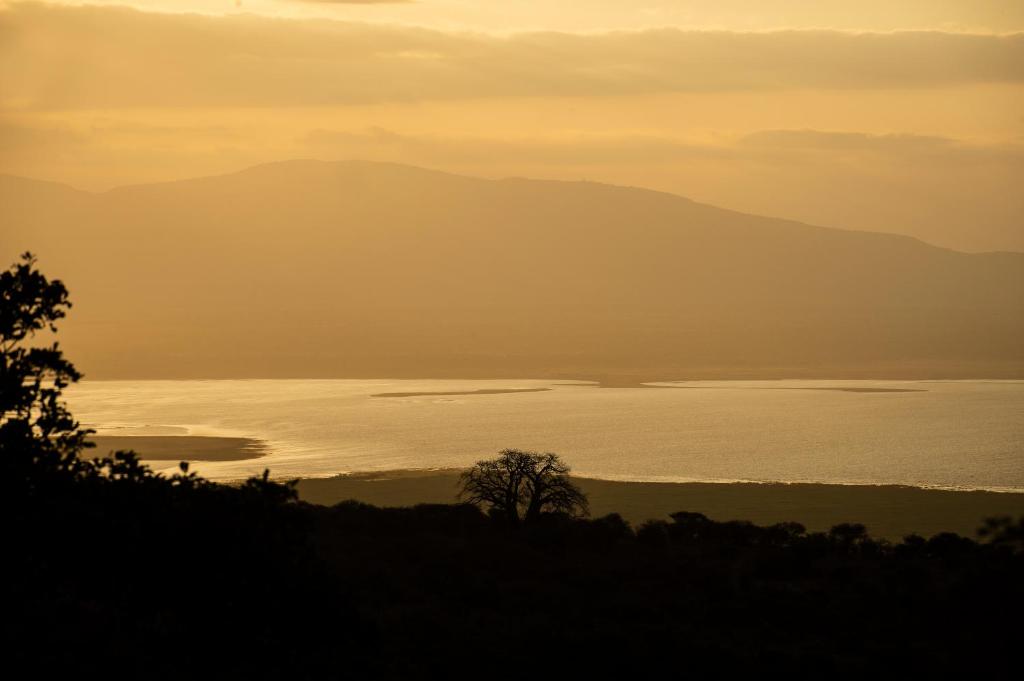 KaitiMawemawe Manyara Lodge的日落时分,享有一大片水景
